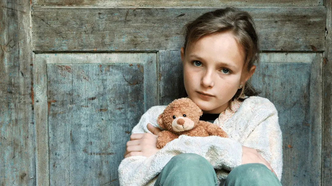 sad little girl holding teddy bear